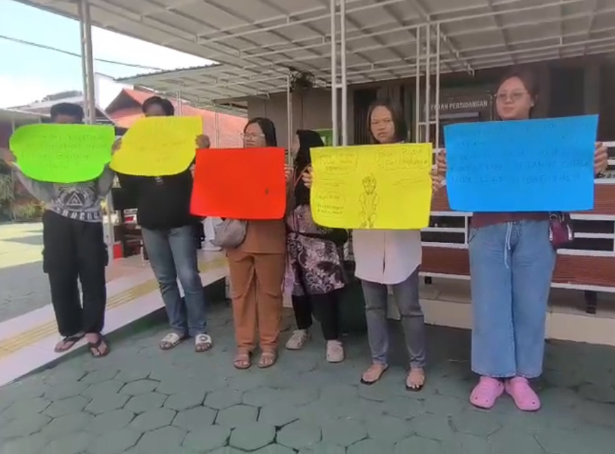 Keluarga Korban Pelecehan Membawa Poster Di Depan PN Malang Menuntut Keadilan