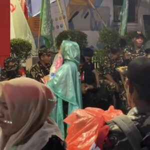 Penjual Mantel Kresek Melayani Jemaah Di Sekitar Stadion Gajayana Saat Hujan Jelang Mujahadah Kubro 1 Abad NU